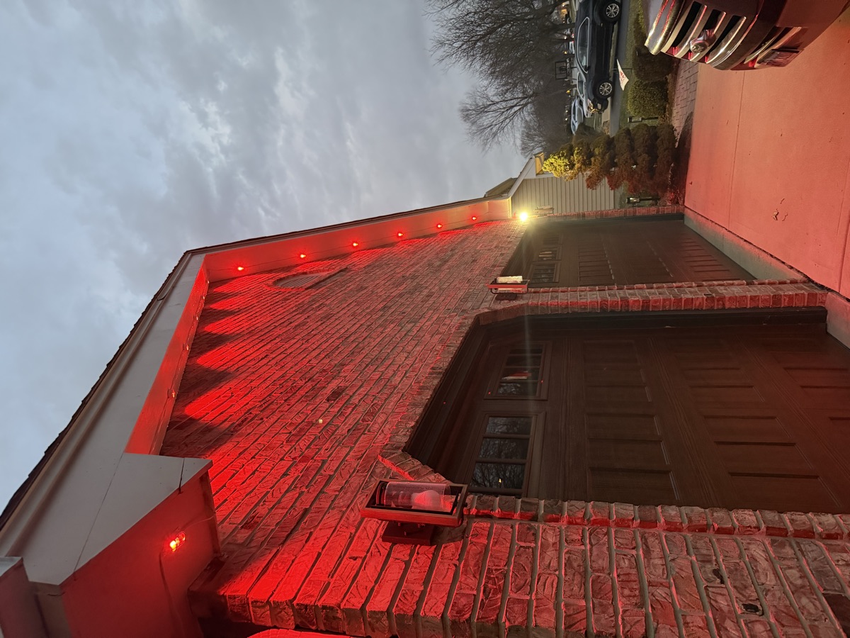Red Govee permanent soffit lights on a brick home